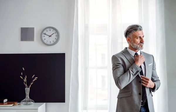 Un serio uomo d'affari maturo in piedi in un ufficio . — Foto Stock