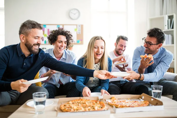 Modern bir ofiste yemek pizza ile Genç İşadamları grubu.