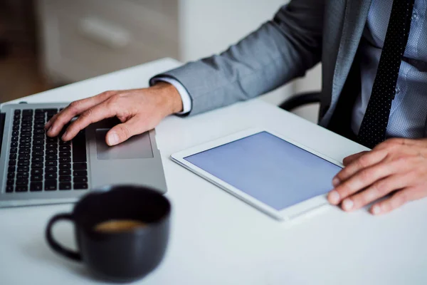 Un milieu d'homme d'affaires assis à la table, en utilisant une tablette. Espace de copie . — Photo