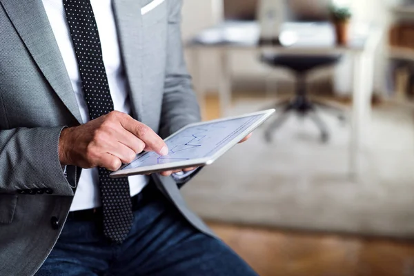 Un milieu d'homme d'affaires assis dans un bureau, en utilisant une tablette. Espace de copie . — Photo