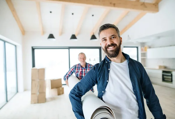 Un homme âgé aidant son fils à meubler une nouvelle maison, un nouveau concept de maison . — Photo