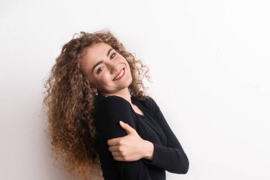 Genç güzel mutlu kadın stüdyoda ayakta.