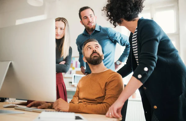 Groep van jonge ondernemers met laptop met vergadering in een modern kantoor. — Stockfoto