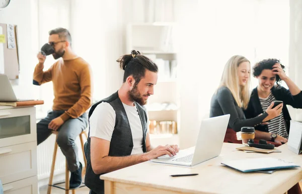 Gruppen av unga företagare med laptop som arbetar i ett modernt kontor. — Stockfoto