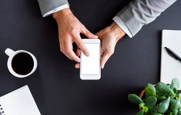 Un milieu d'homme d'affaires assis à la table, à l'aide d'un smartphone. Une vue de dessus. Espace de copie . — Photo