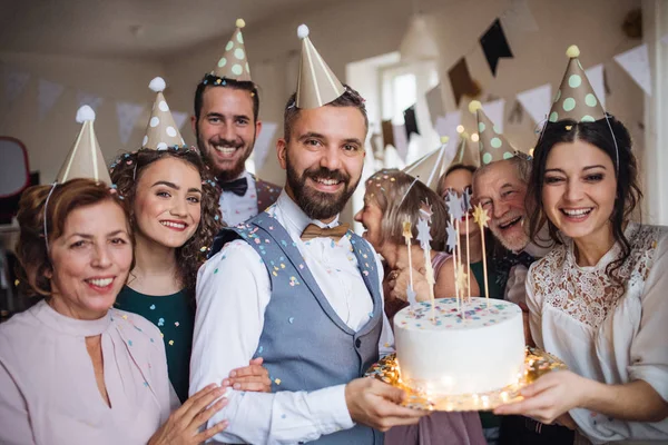 Um retrato de família de várias gerações com um bolo em uma festa de aniversário indoor . — Fotografia de Stock