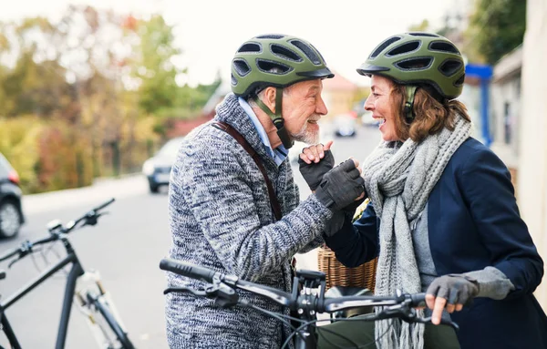 活跃的高级夫妇爱上了站在镇上一条路上的电动自行车. — 图库照片