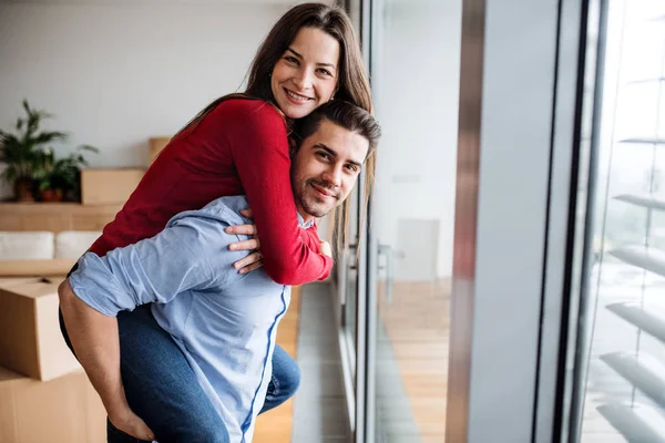 Genç çift yeni bir ev içinde hareket eğleniyor. — Stok fotoğraf