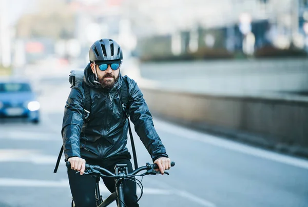 Eine Frontansicht männlicher Fahrradkuriere, die Pakete in der Stadt ausliefern. Kopierraum. — Stockfoto