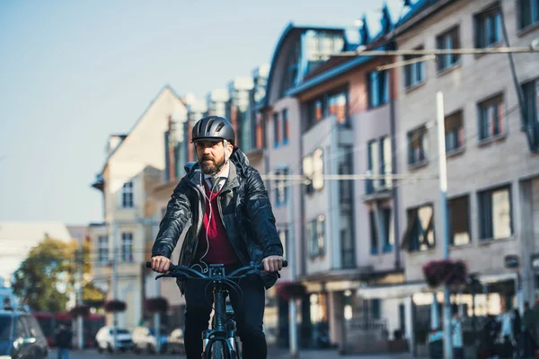 Hipster viajero de negocios con bicicleta eléctrica viajando a casa desde el trabajo en la ciudad . — Foto de Stock