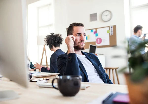 Gruppen av unga företagare med smartphone som arbetar tillsammans i ett modernt kontor. — Stockfoto