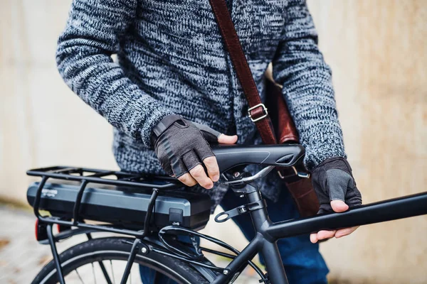 A midsection of a cyclist with electrobike standing outdoors in town. — Stock Photo, Image