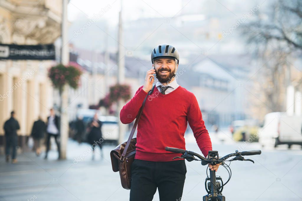 Hipster businessman commuter with bicycle and smartphone on the way to work in city.