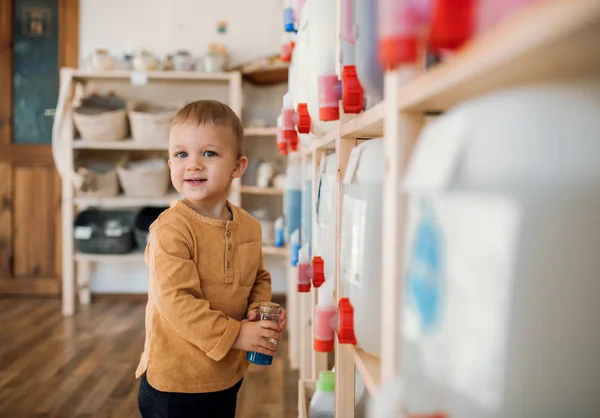 ゼロ廃棄物ショップでディスペンサーで立っている小さな幼児少年. — ストック写真