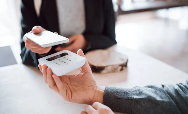 Een buik van klant en winkelbediende maken van mobiel betalen in een winkel. — Stockfoto