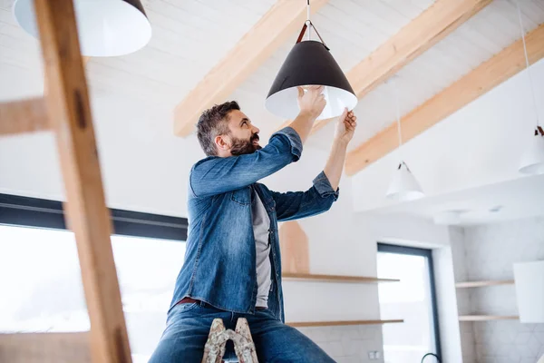 Un hombre maduro amueblando una casa nueva, un nuevo concepto de hogar . — Foto de Stock