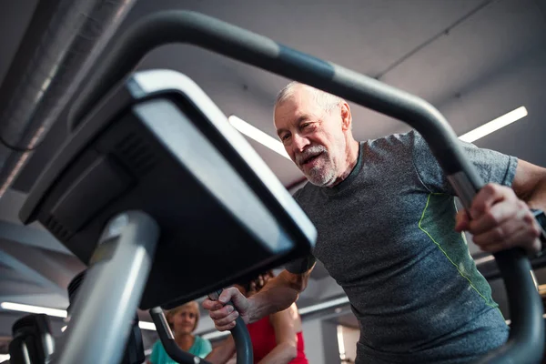 En äldre man gör styrka träning övning i gymmet. Kopiera utrymme. — Stockfoto