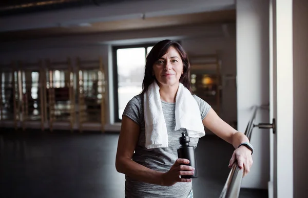 Eine Seniorin im Fitnessstudio, die sich nach dem Sport ausruht. Kopierraum. — Stockfoto