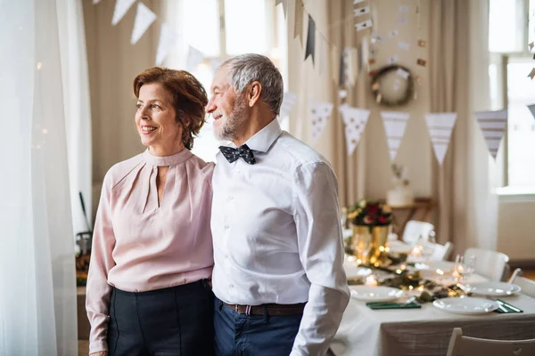 Couple de personnes âgées debout à l'intérieur dans une pièce prévue pour une fête. Espace de copie . — Photo