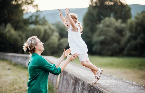 Jonge moeder in de natuur met kleine dochter, plezier. — Stockfoto