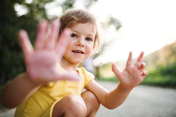 Une petite fille mignonne sur une route à la campagne dans la nature ensoleillée d'été . — Photo