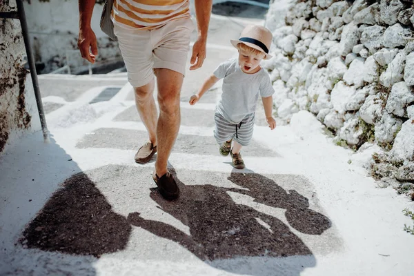 Ένα μεσαίο τμήμα του πατέρα με τον γιο του νήπιο το περπάτημα στην πόλη για διακοπές το καλοκαίρι. — Φωτογραφία Αρχείου