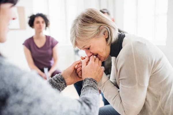 Eine depressive Seniorin weint während einer Gruppentherapie. — Stockfoto