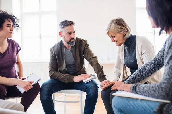 Men and women sitting in a circle during group therapy, supporting each other. — Stock Photo, Image