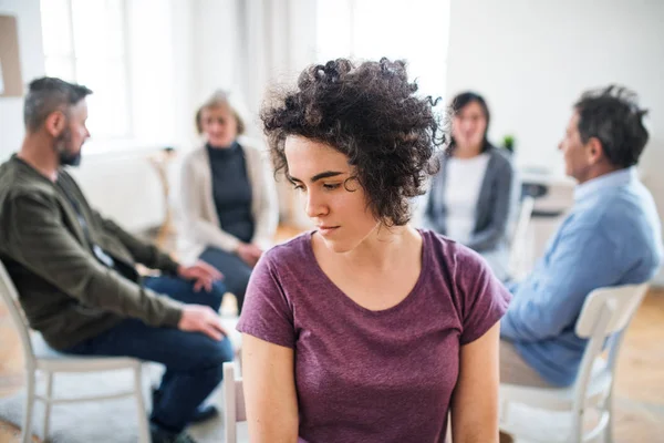 A portrait of young depressed woman during group therapy. — Stock Photo, Image