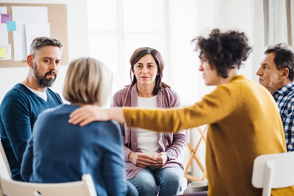 Mannen en vrouwen zitten in een cirkel tijdens groepstherapie, steunen elkaar. — Stockfoto