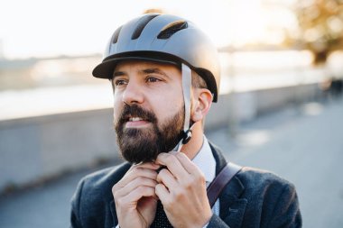 Ne zaman eve iş City seyahat bir bisiklet kask koyarak hipster işadamı banliyö.