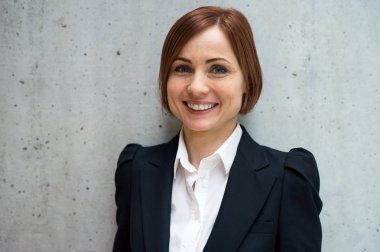 Ofiste ayakta, kameraya bakarak Genç işkadını portresi.