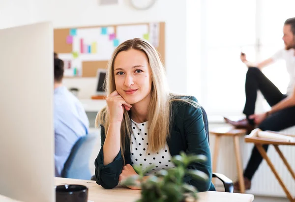 Ett porträtt av ung affärskvinna sitter i ett modernt kontor. — Stockfoto