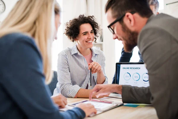 Gruppe junger Geschäftsleute mit Laptop arbeitet zusammen in einem modernen Büro. — Stockfoto