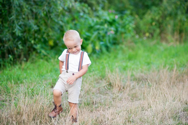 A cute cheeky small toddler boy in sunny summer nature. Copy space. — Stock Photo, Image