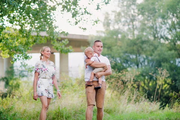 Ung familj med en liten gråtande barn pojke i solig sommar naturen. — Stockfoto