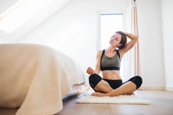 Eine junge Frau, die in einem Schlafzimmer Sport treibt. Kopierraum. — Stockfoto