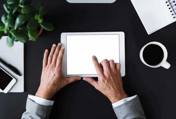 Een bovenaanzicht van mannelijke handen hodling tablet op een bureau. Kopiëren van ruimte. — Stockfoto