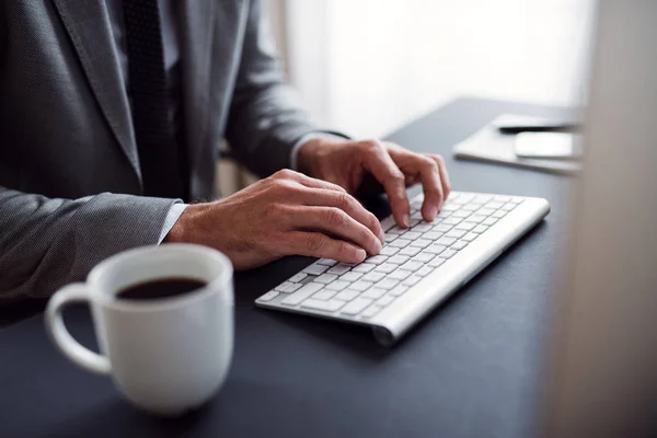 Un milieu d'homme d'affaires avec ordinateur assis au bureau, travaillant . — Photo