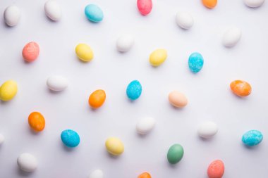 Renkli yumurta düz beyaz bir arka plan üzerinde yatıyordu. Paskalya ve bahar kompozisyon.