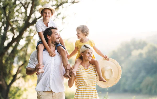 Familia joven con niños pequeños en la naturaleza soleada del verano . —  Fotos de Stock