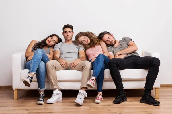 Porträtt av ung grupp vänner sitter på en soffa i en studio, sover. — Stockfoto