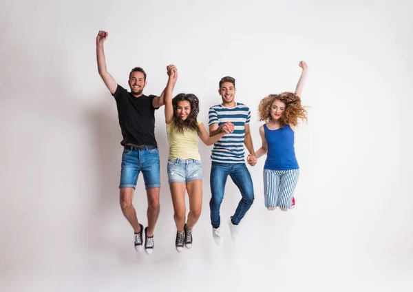 Retrato de jovem grupo alegre de amigos pulando em um estúdio . — Fotografia de Stock