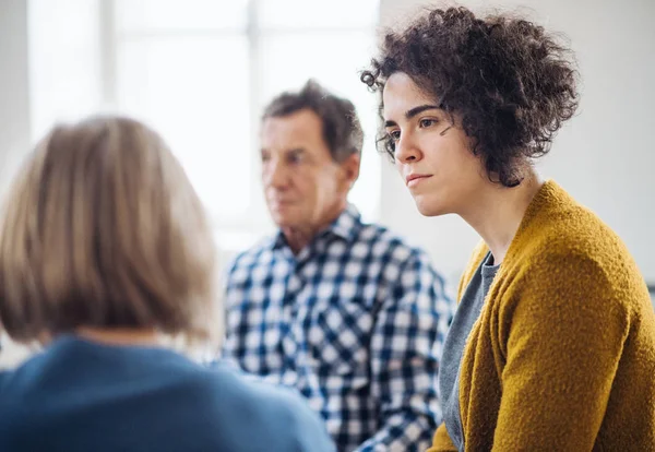 Men and women sitting in a circle during group therapy, talking. — Stock Photo, Image