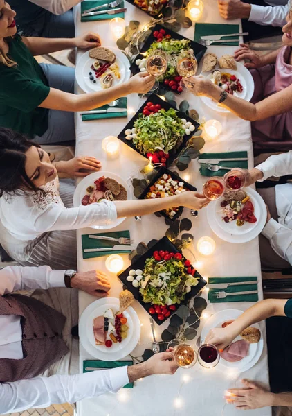 Una vista superior de la gran familia sentada en una mesa en una fiesta de cumpleaños cubierta, gafas de tintineo . — Foto de Stock