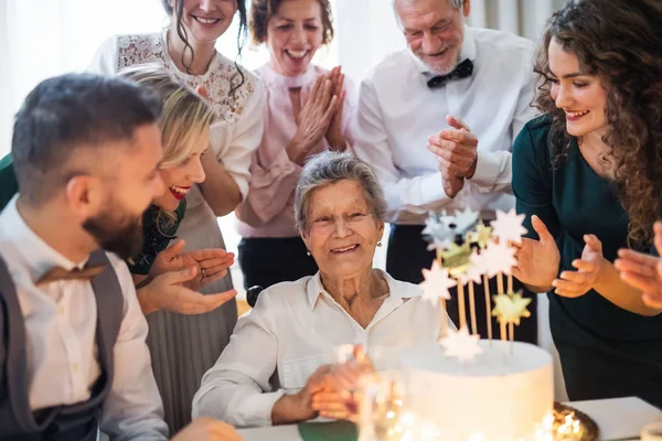 Una anciana con familia multigeneracional celebrando cumpleaños en fiesta de interior . — Foto de Stock