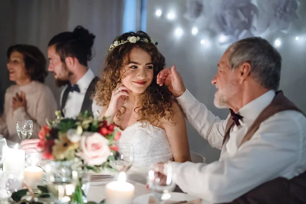 Любящий отец и красивая невеста сидят за столом на свадьбе, разговаривают . — стоковое фото