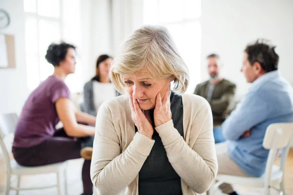 Ett porträtt av senior deprimerad kvinna under gruppterapi. — Stockfoto