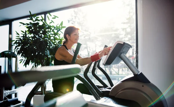 Wesoły kobieta senior w siłowni robi cardio workout. — Zdjęcie stockowe