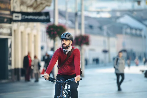 Hipster viajero de negocios con bicicleta eléctrica que viaja a trabajar en la ciudad . — Foto de Stock